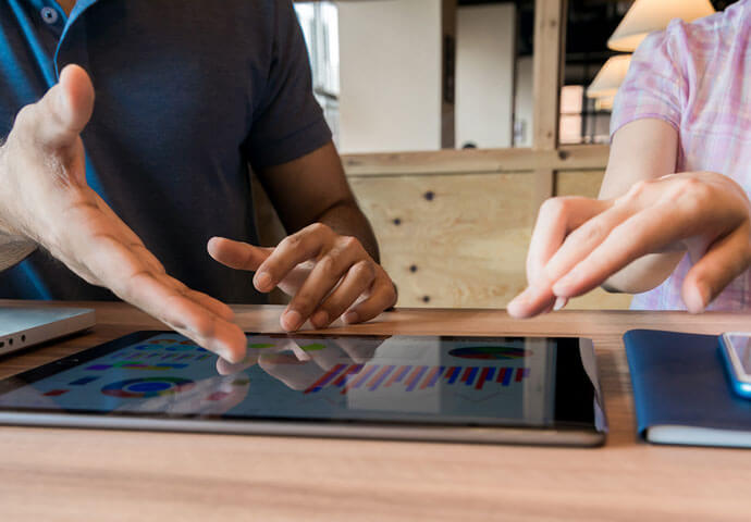 Close up of hands pointing to tablet screen